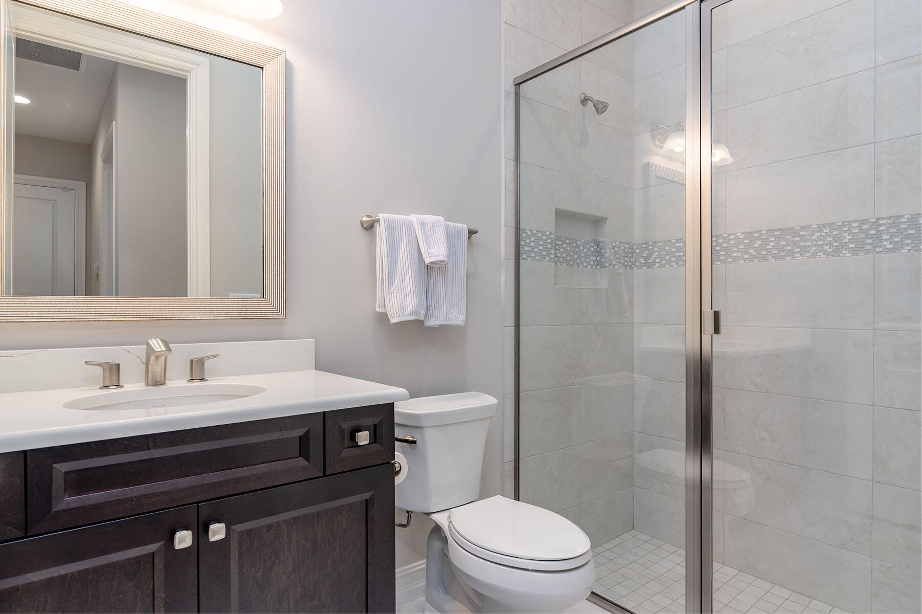 3192 Capistrano Lane Naples, FL 34114 - Photo 17 of 38 a bathroom with a sink toilet vanity and shower