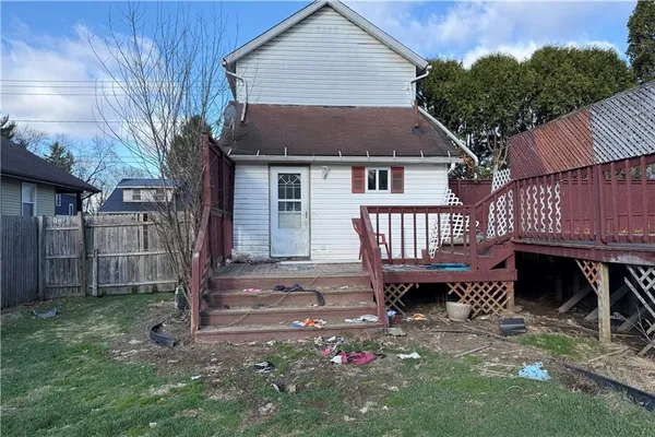 a view of a house with a yard and wooden fence
