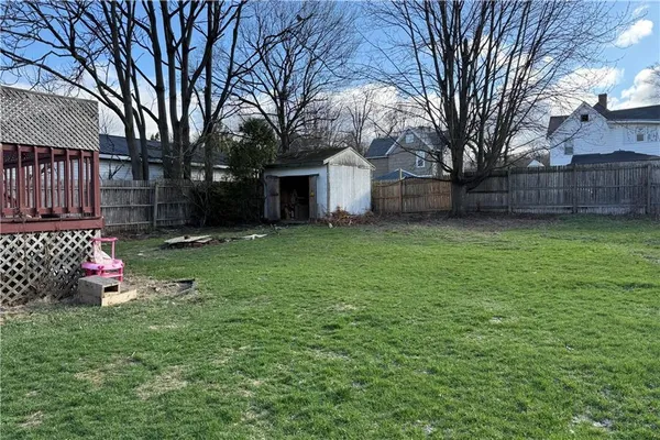 a front view of a house with a garden and trees