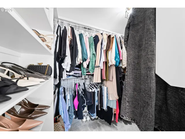 a view of walk in closet with clothes