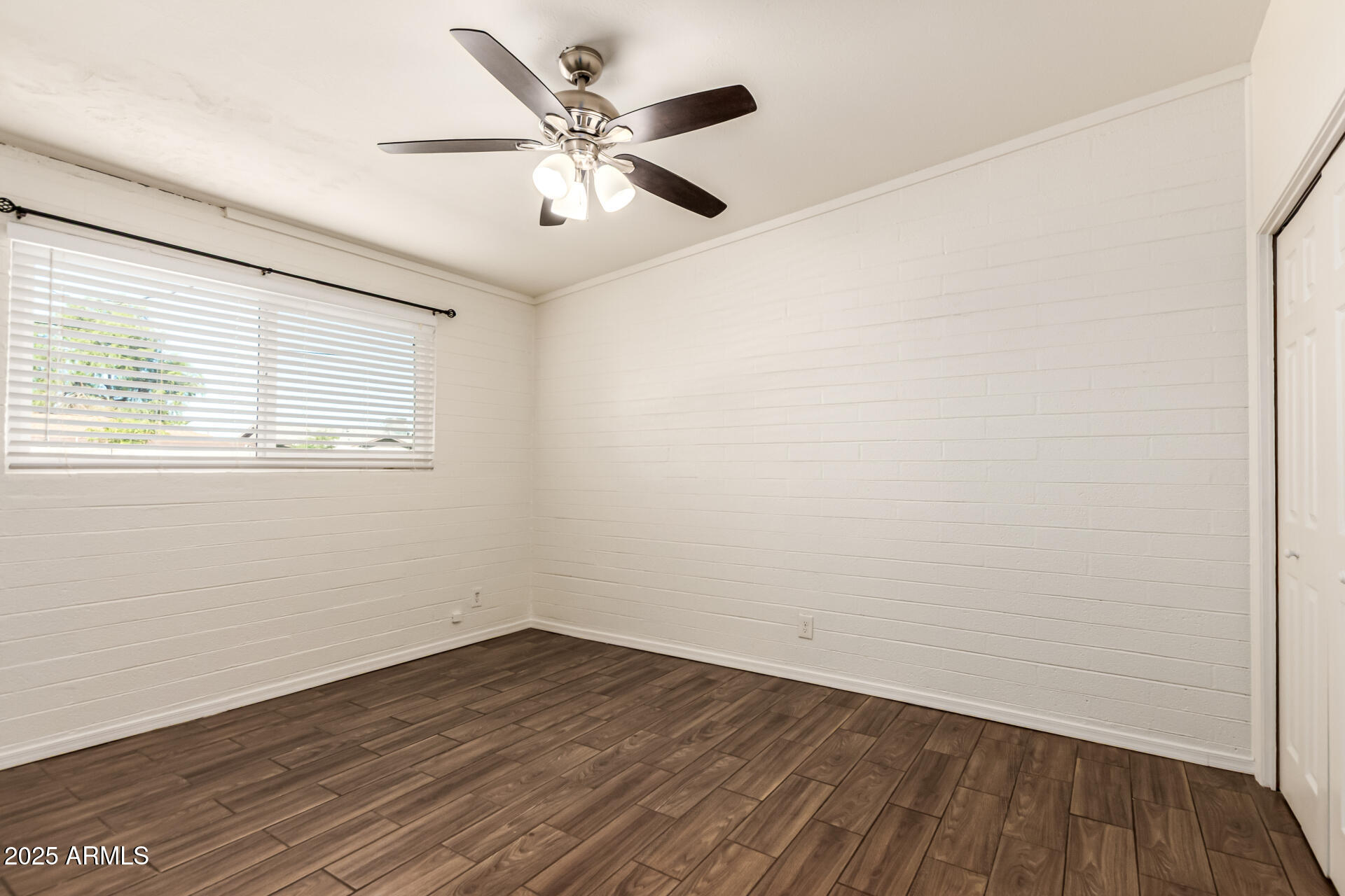 2150 West Missouri Avenue, Unit 108 Phoenix, AZ 85015 - Photo 10 of 28 an empty room with wooden floor and windows
