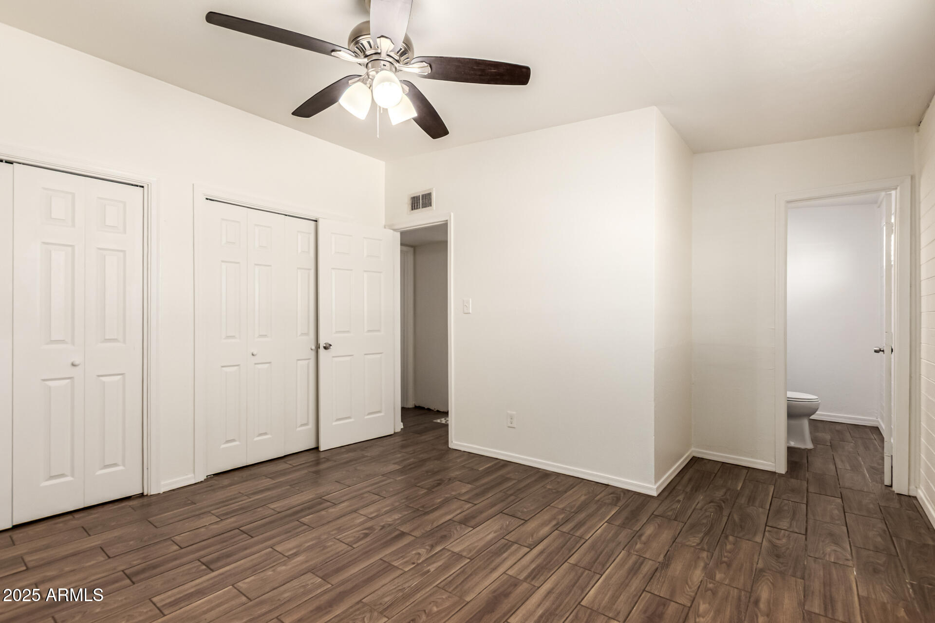 2150 West Missouri Avenue, Unit 108 Phoenix, AZ 85015 - Photo 11 of 28 a view of room with hardwood floor and ceiling fan