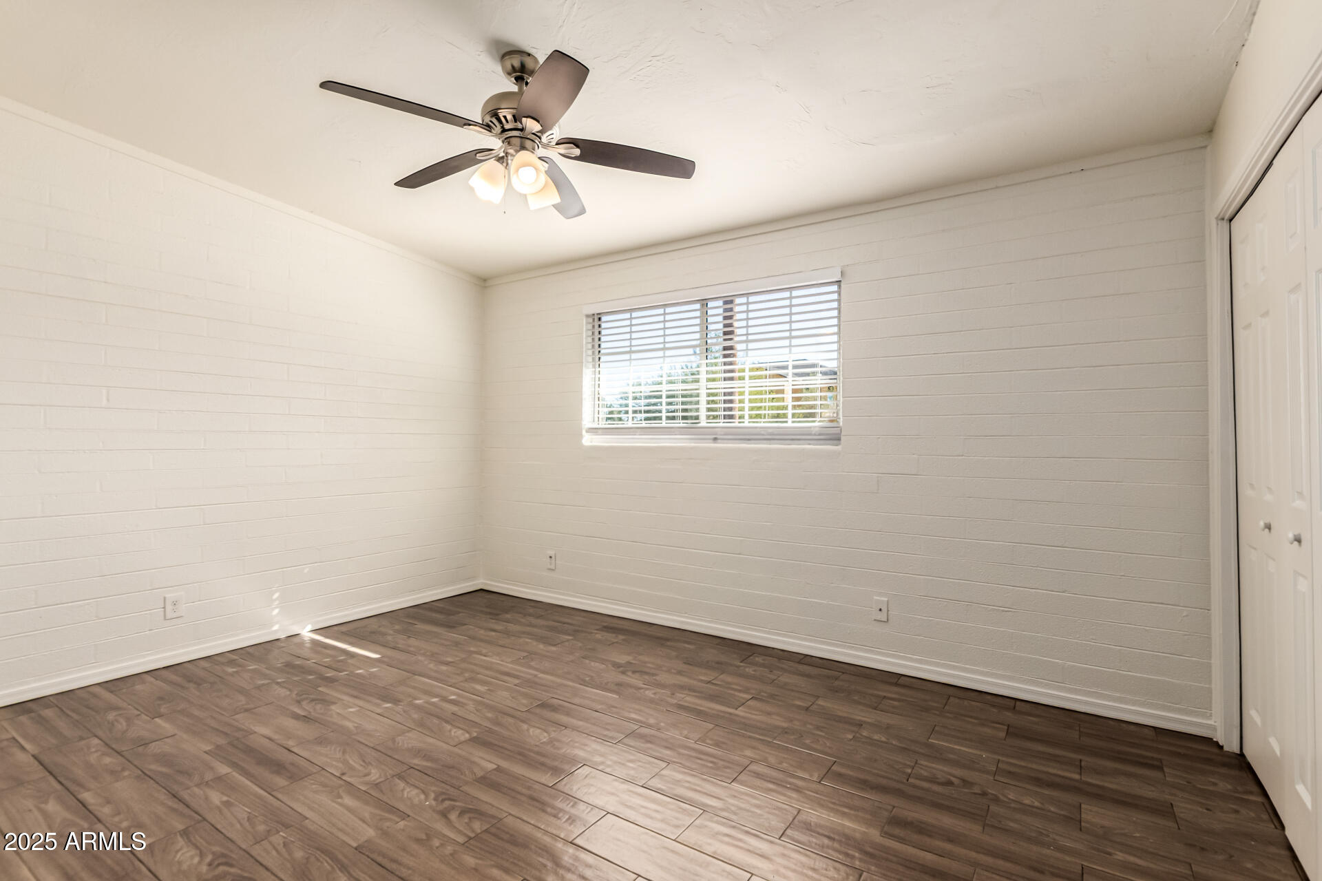 2150 West Missouri Avenue, Unit 108 Phoenix, AZ 85015 - Photo 15 of 28 an empty room with wooden floor and windows