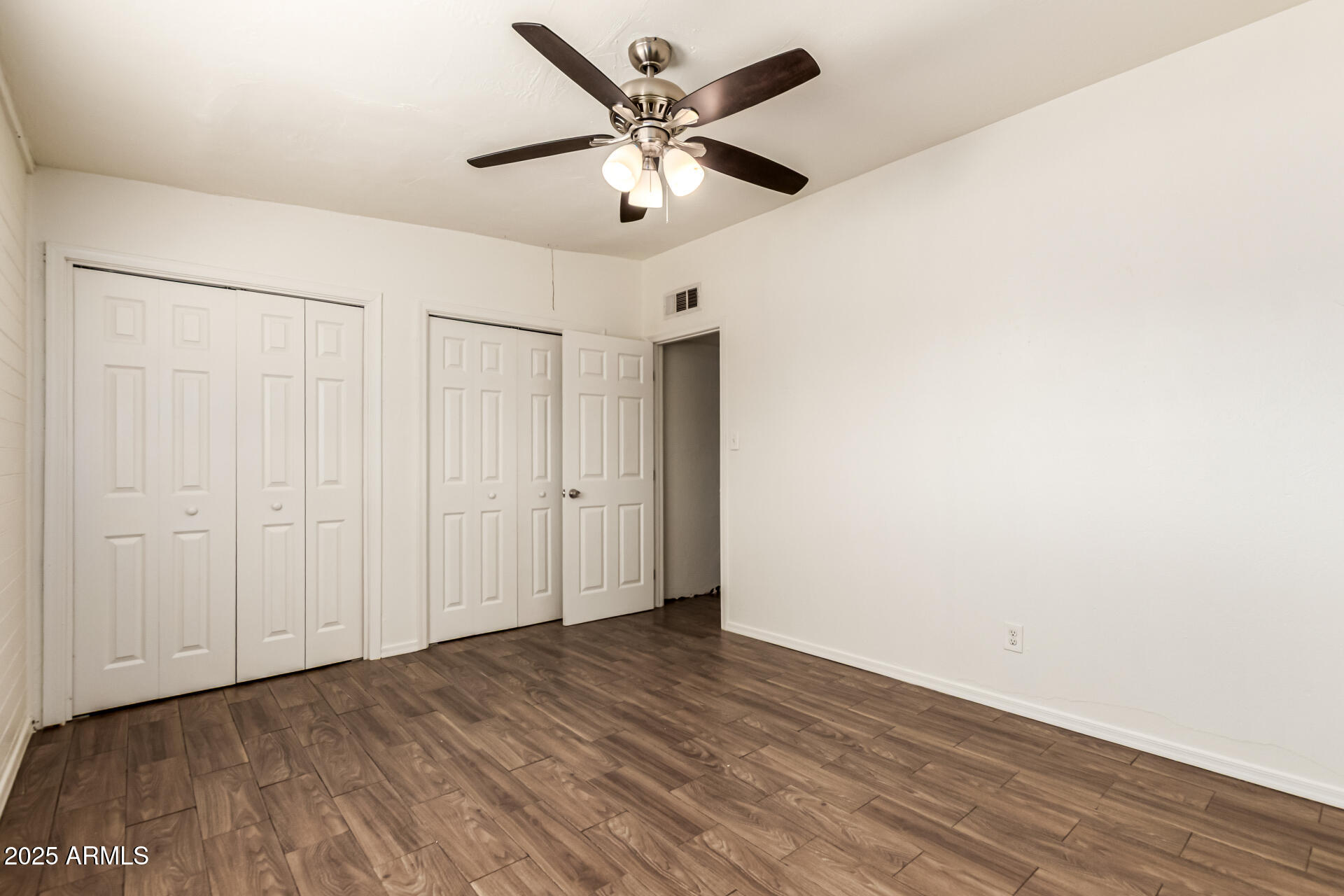 2150 West Missouri Avenue, Unit 108 Phoenix, AZ 85015 - Photo 16 of 28 a view of an empty room with wooden floor