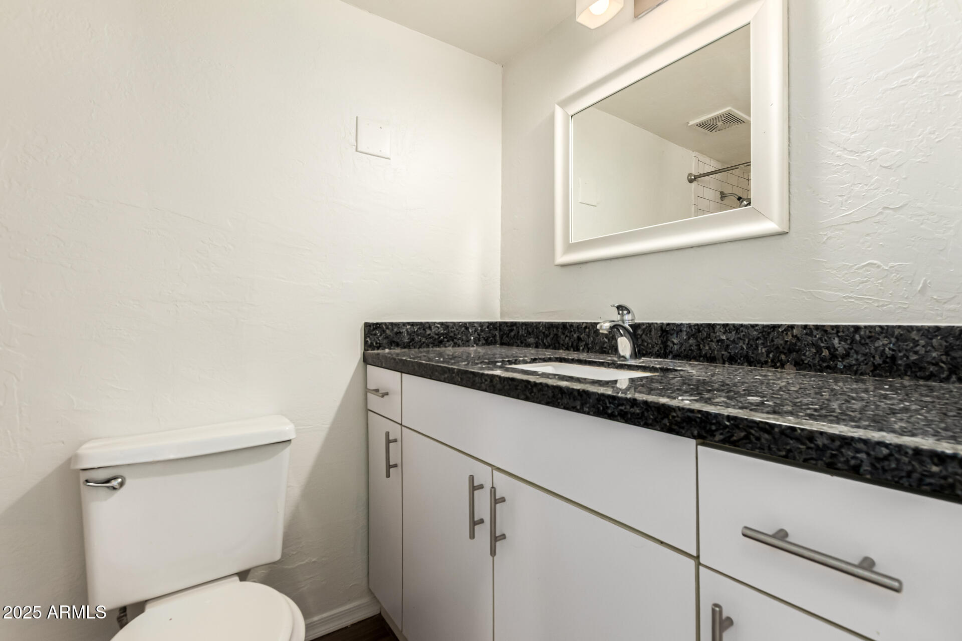 2150 West Missouri Avenue, Unit 108 Phoenix, AZ 85015 - Photo 18 of 28 a bathroom with a toilet a sink and mirror