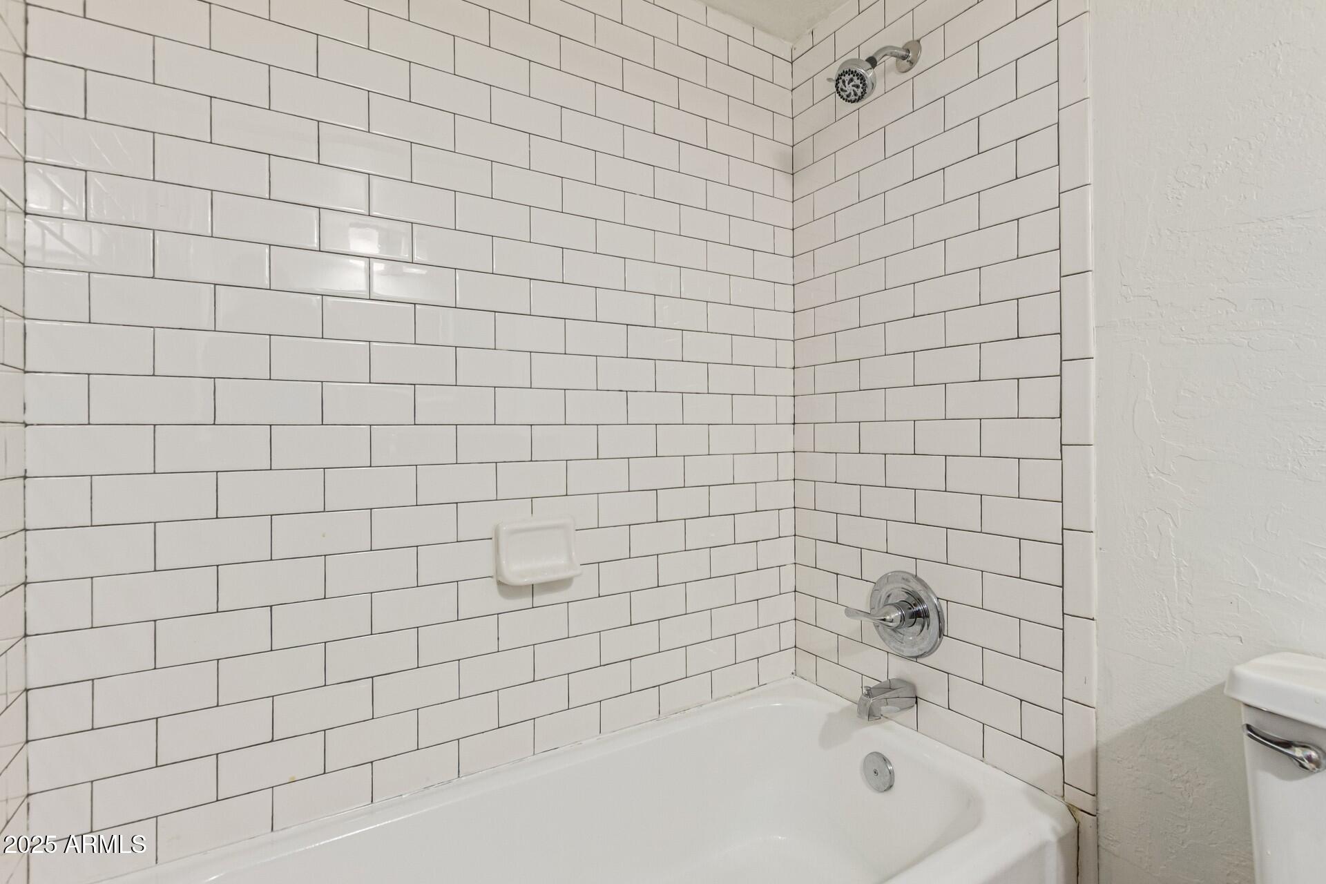 2150 West Missouri Avenue, Unit 108 Phoenix, AZ 85015 - Photo 19 of 28 a bathroom with a bathtub and shower
