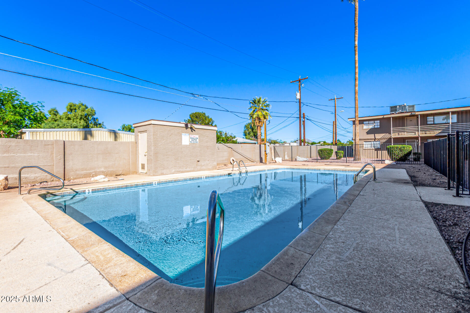 2150 West Missouri Avenue, Unit 108 Phoenix, AZ 85015 - Photo 25 of 28 a view of a swimming pool with a lounge chairs