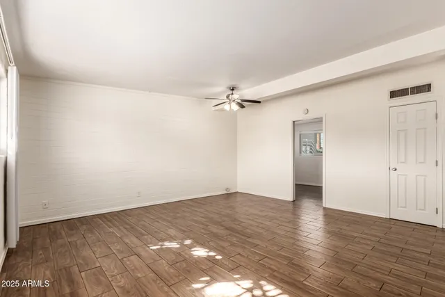 a view of empty room with wooden floor