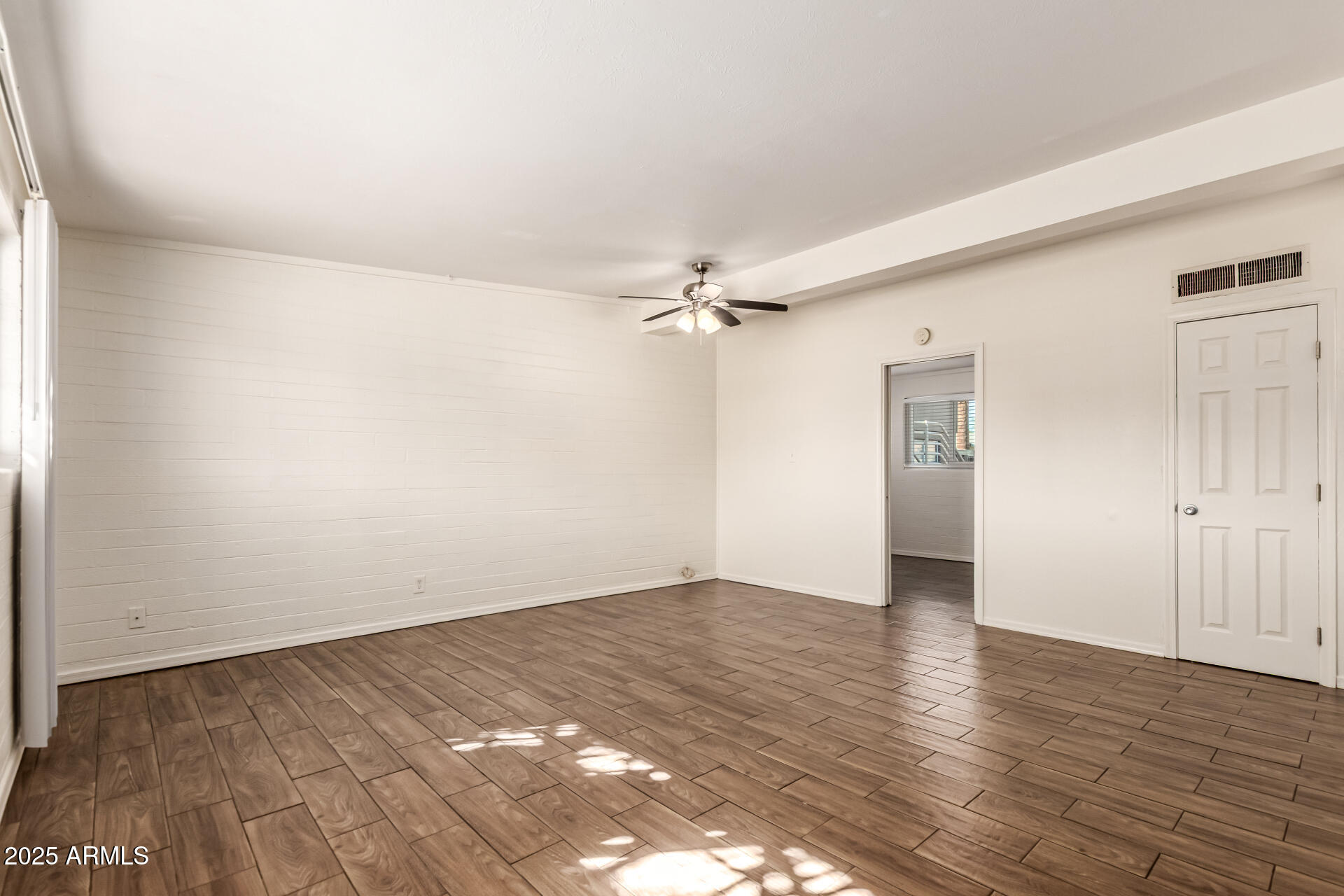 2150 West Missouri Avenue, Unit 108 Phoenix, AZ 85015 - Photo 4 of 28 an empty room with wooden floor closet and windows