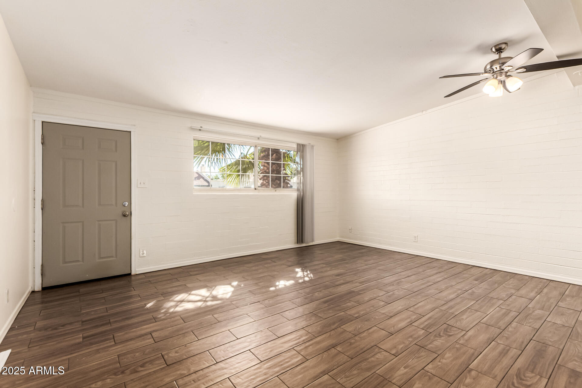 2150 West Missouri Avenue, Unit 108 Phoenix, AZ 85015 - Photo 6 of 28 a view of an empty room with wooden floor and a window