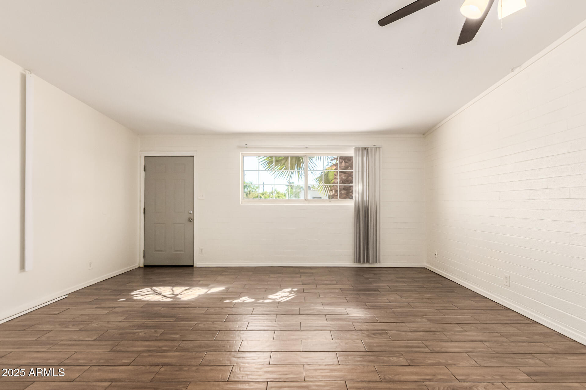 2150 West Missouri Avenue, Unit 108 Phoenix, AZ 85015 - Photo 7 of 28 a view of an empty room with wooden floor and a window