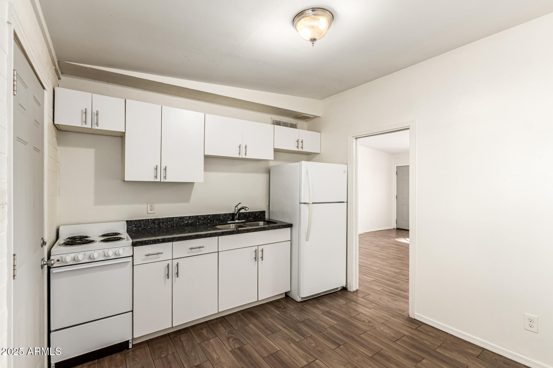 2150 West Missouri Avenue, Unit 108 Phoenix, AZ 85015 - Photo 8 of 28 a kitchen with stainless steel appliances a sink cabinets and wooden floor