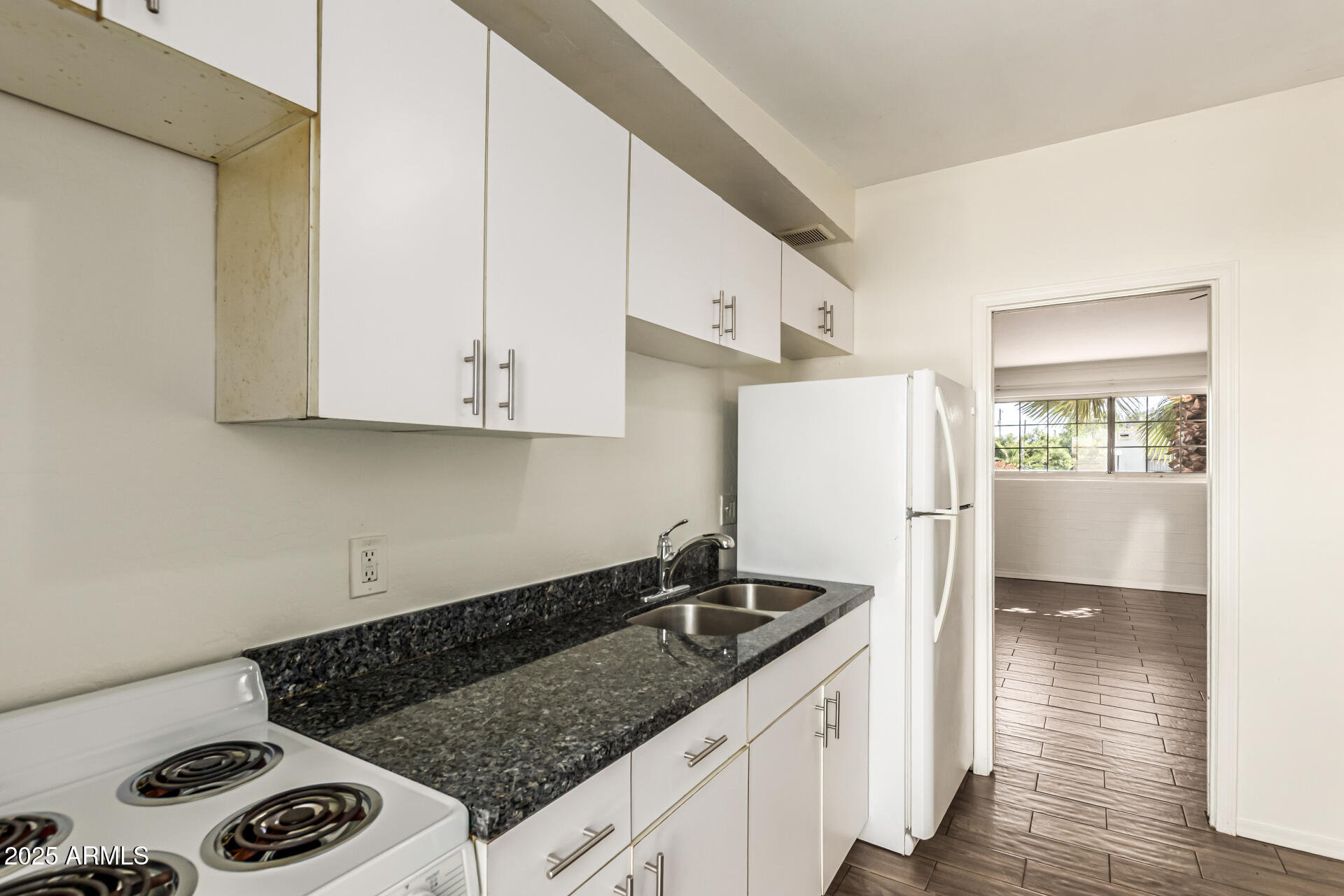 2150 West Missouri Avenue, Unit 108 Phoenix, AZ 85015 - Photo 9 of 28 a kitchen with granite countertop a sink stove and cabinets