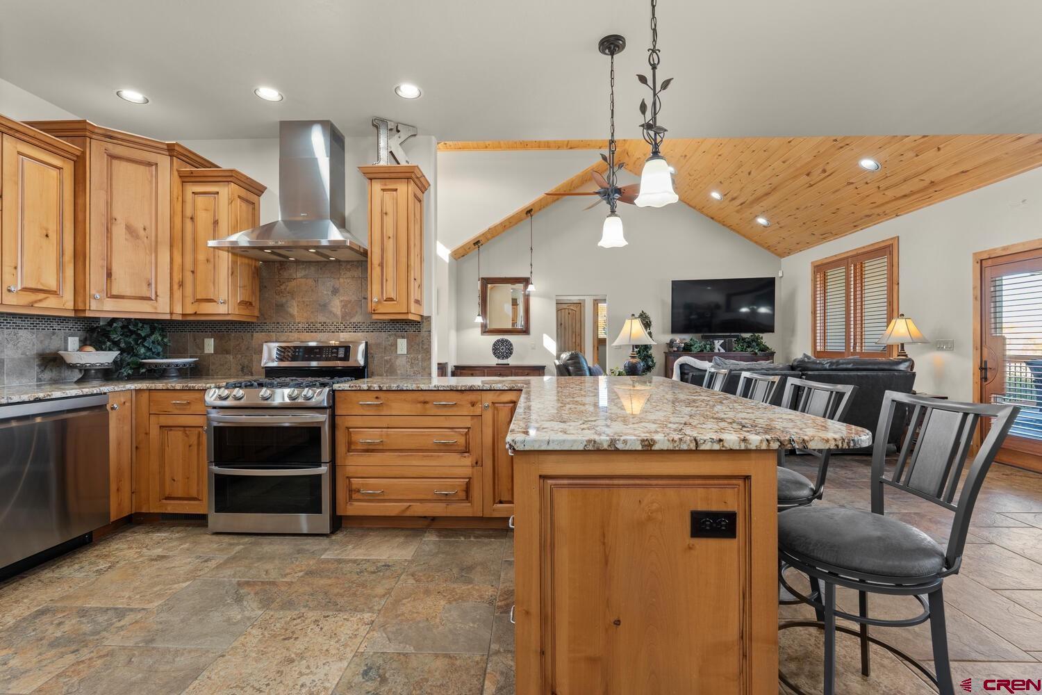 60075-60085 Oak Grove Road Montrose, CO 81403 - Photo 12 of 44 a kitchen with kitchen island granite countertop a stove and a view of living room