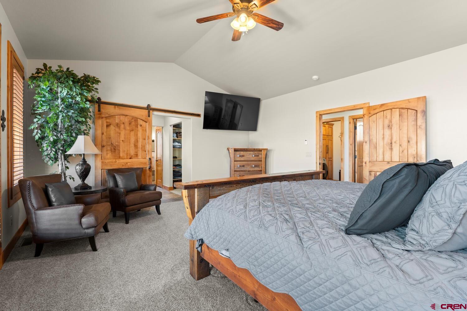 60075-60085 Oak Grove Road Montrose, CO 81403 - Photo 14 of 44 a bedroom with a bed a couch and a chandelier