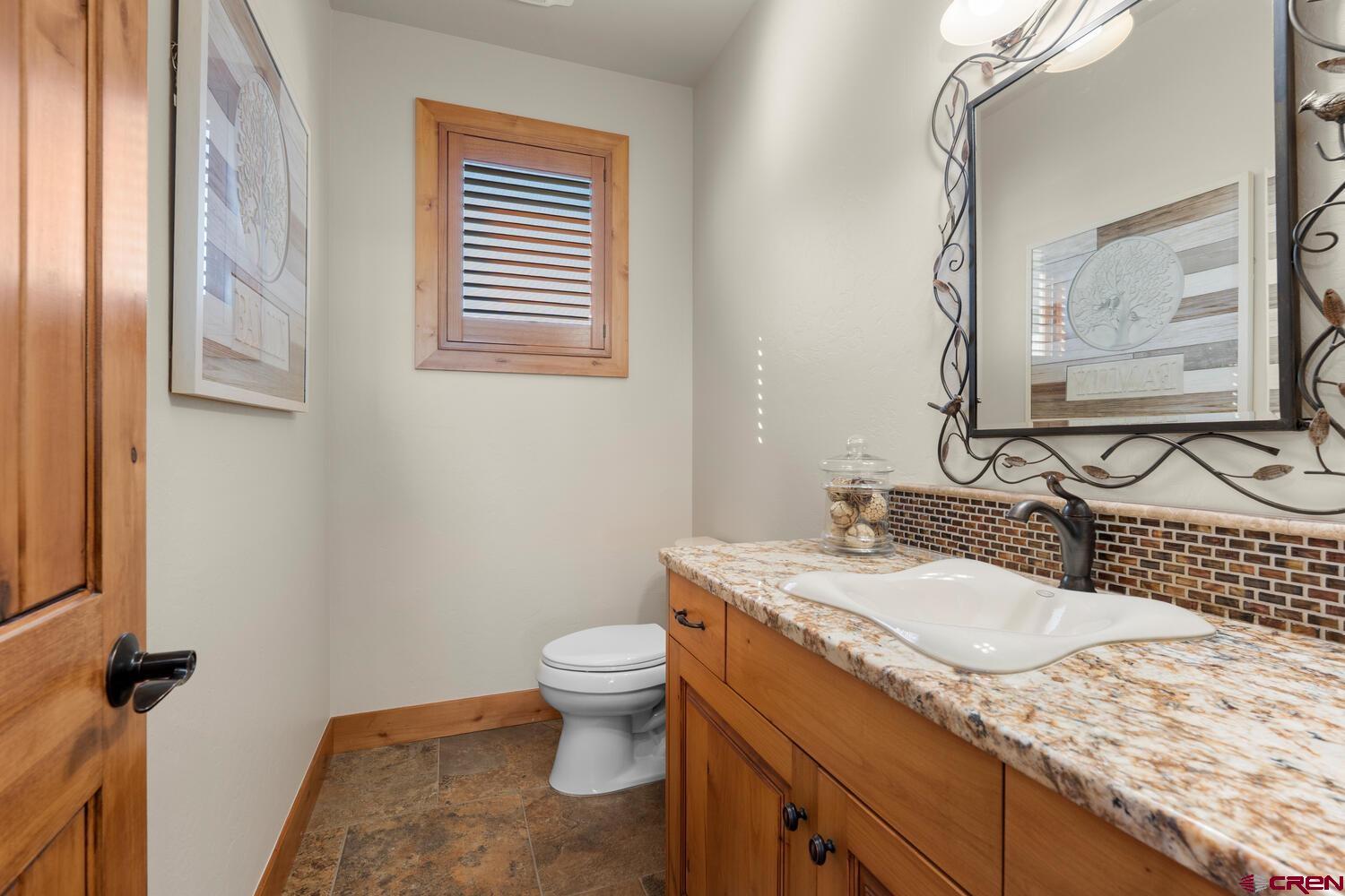 60075-60085 Oak Grove Road Montrose, CO 81403 - Photo 18 of 44 a bathroom with a granite countertop sink and a mirror