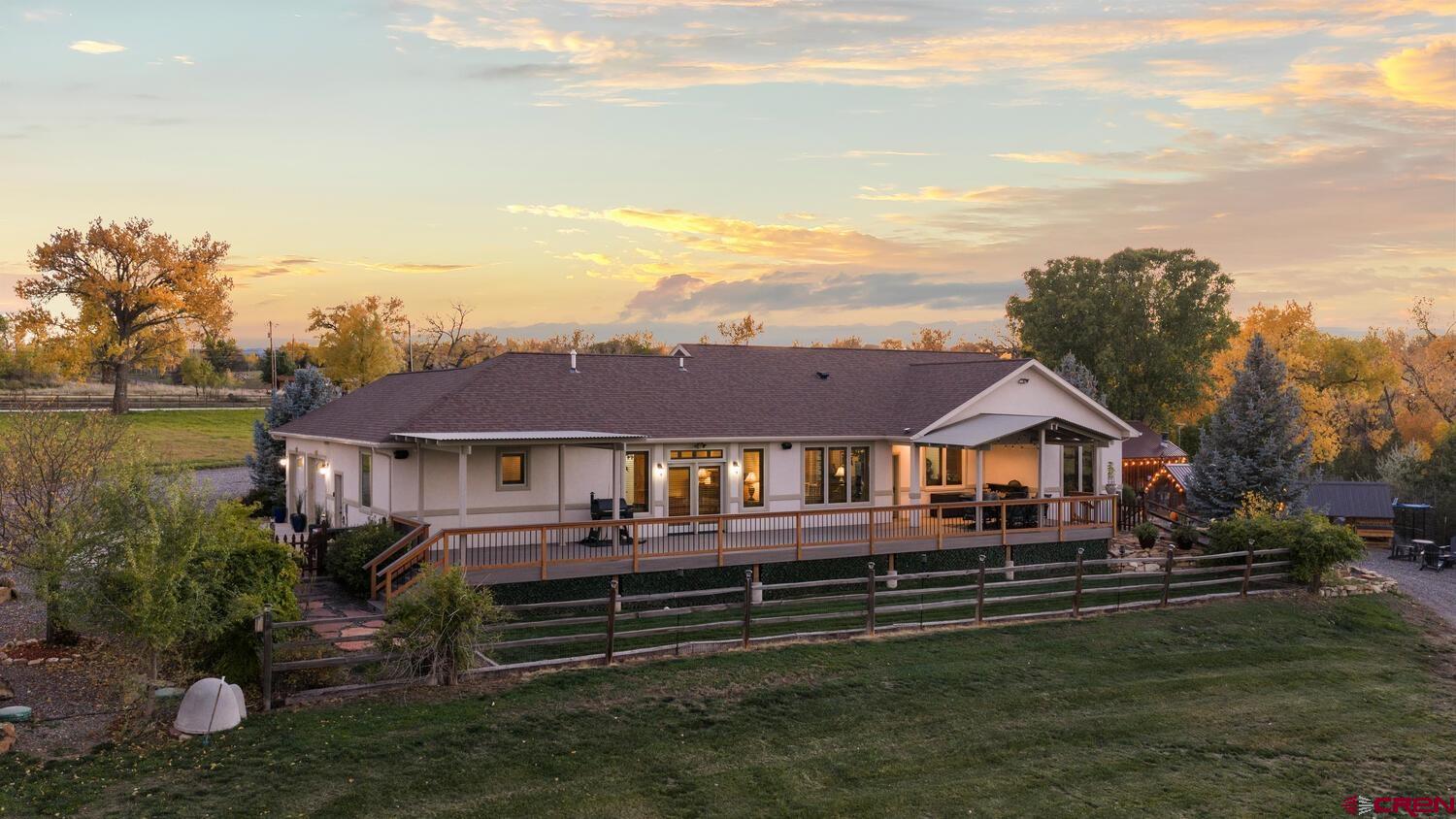 60075-60085 Oak Grove Road Montrose, CO 81403 - Photo 21 of 44 a front view of a house with a garden and lake view
