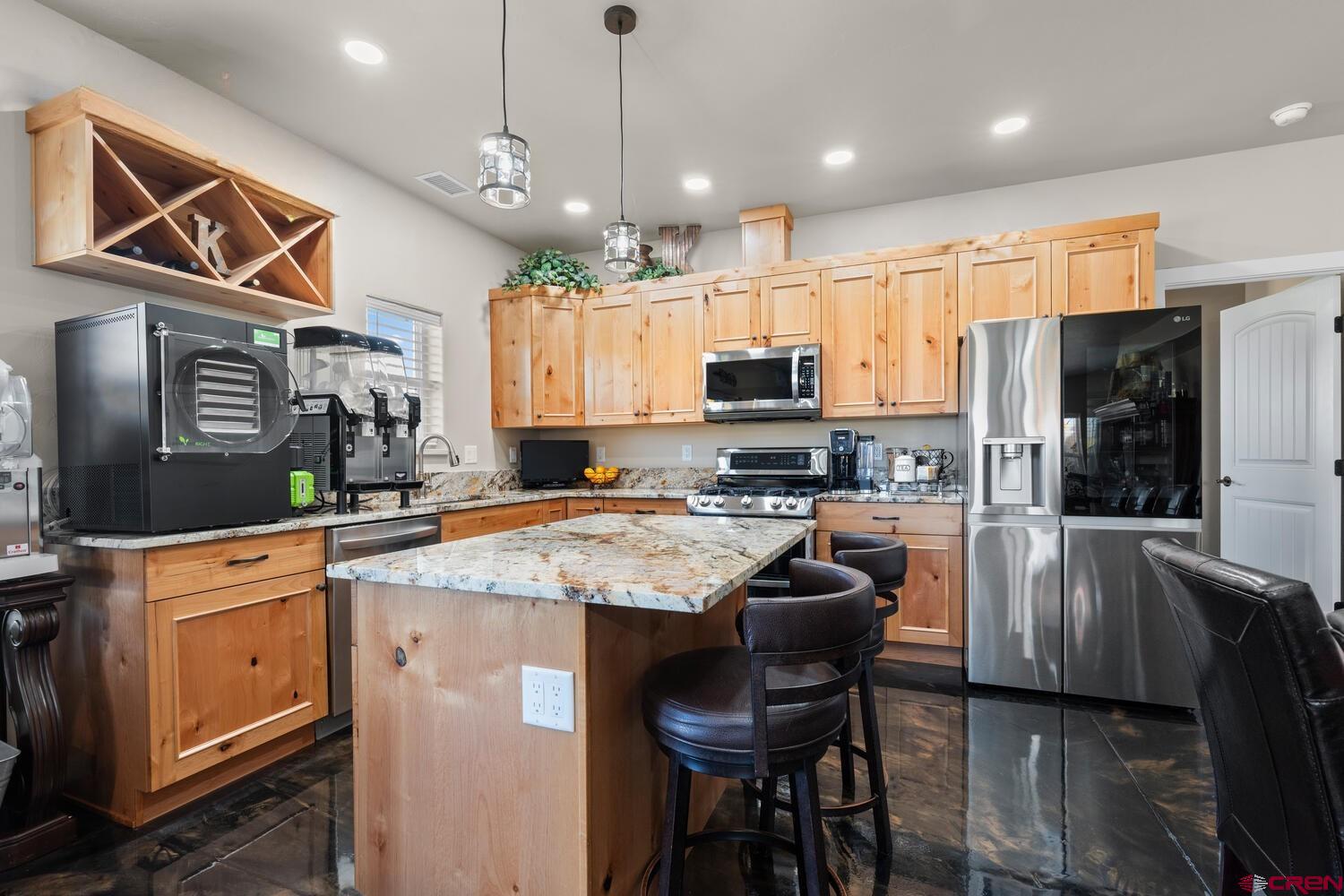 60075-60085 Oak Grove Road Montrose, CO 81403 - Photo 30 of 44 a kitchen with stainless steel appliances kitchen island granite countertop a sink a stove a refrigerator cabinets and chairs