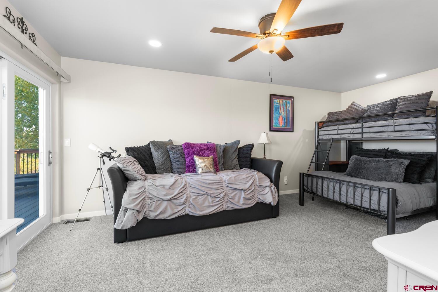 60075-60085 Oak Grove Road Montrose, CO 81403 - Photo 35 of 44 a spacious bedroom with a bed a couch and a chandelier