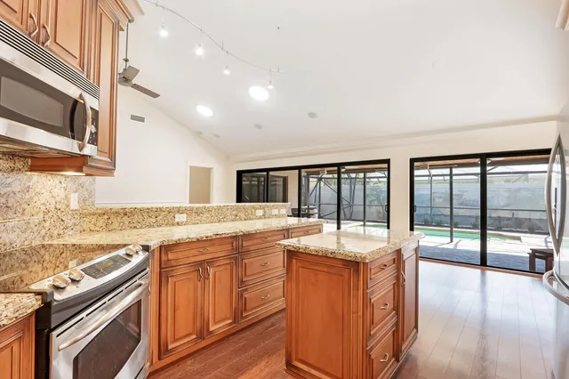 a large kitchen with granite countertop a sink and cabinets