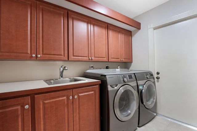 a utility room with sink dryer and washer