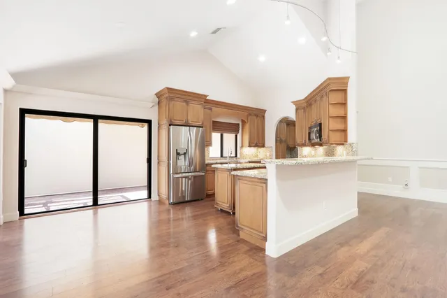 a kitchen with a refrigerator and white cabinets
