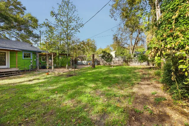 a backyard of a house with lots of green space and fountain
