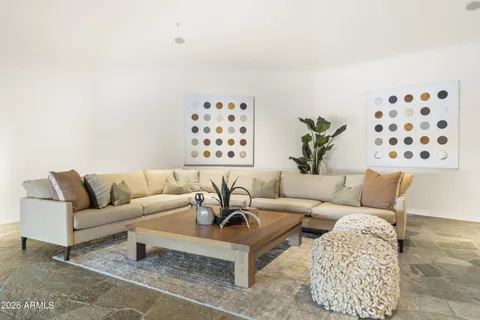 a living room with furniture a large window and a flat screen tv