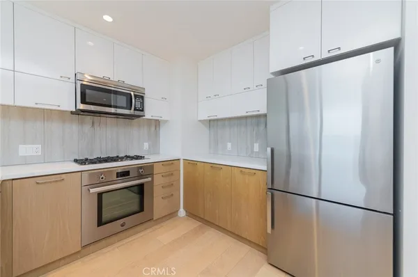 a view of kitchen with refrigerator sink and cabinets
