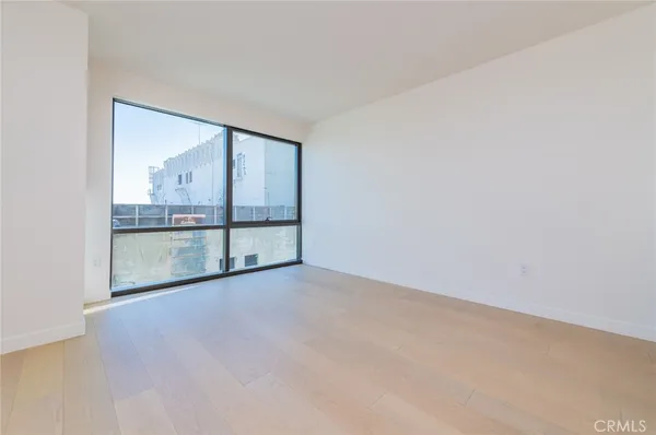 a large kitchen with stainless steel appliances granite countertop a refrigerator a stove and a sink with wooden floor