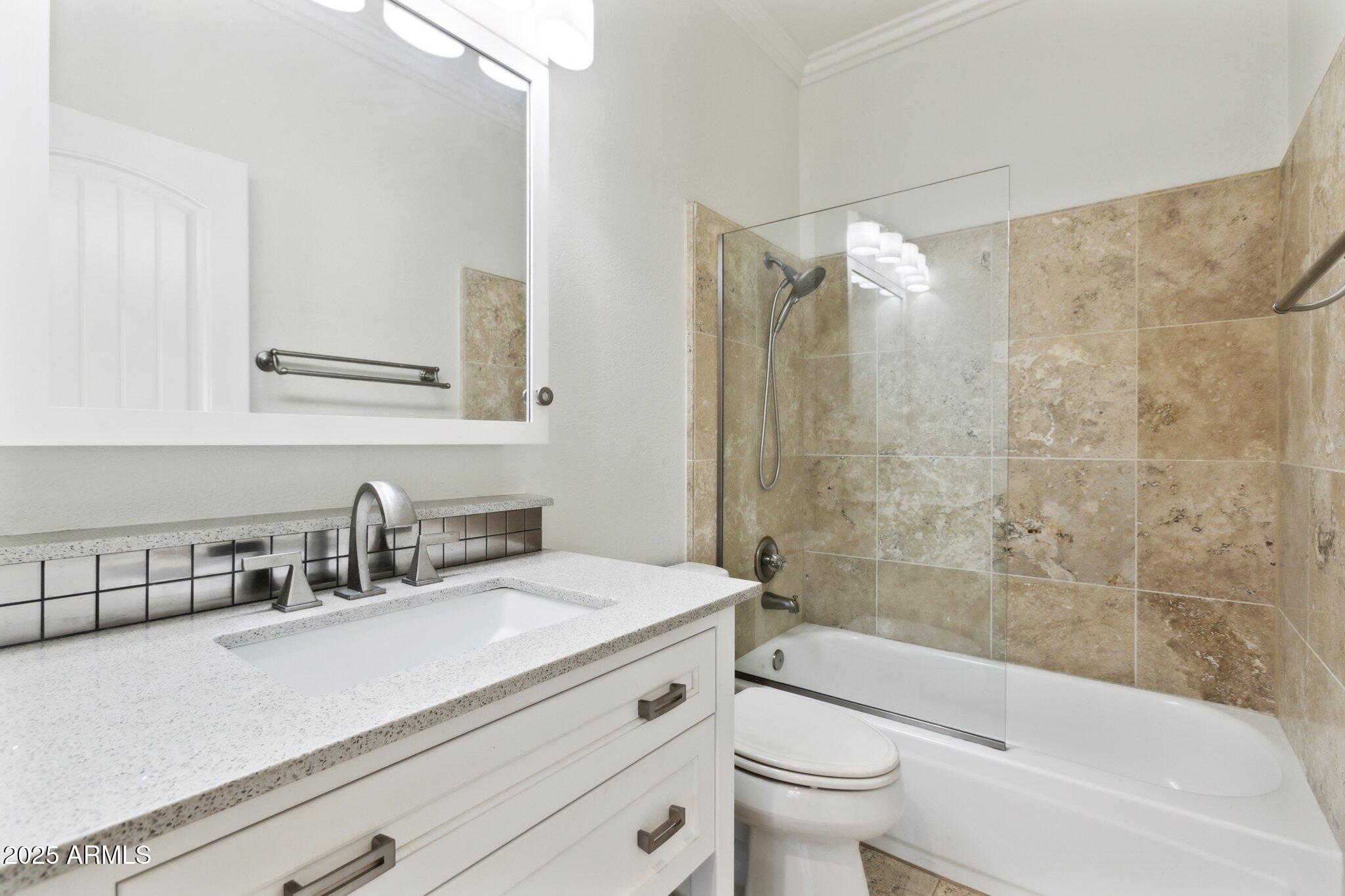 7710 East Gainey Ranch Road, Unit 229 Scottsdale, AZ 85258 - Photo 25 of 50 a bathroom with a granite countertop sink a toilet a mirror a bathtub and shower