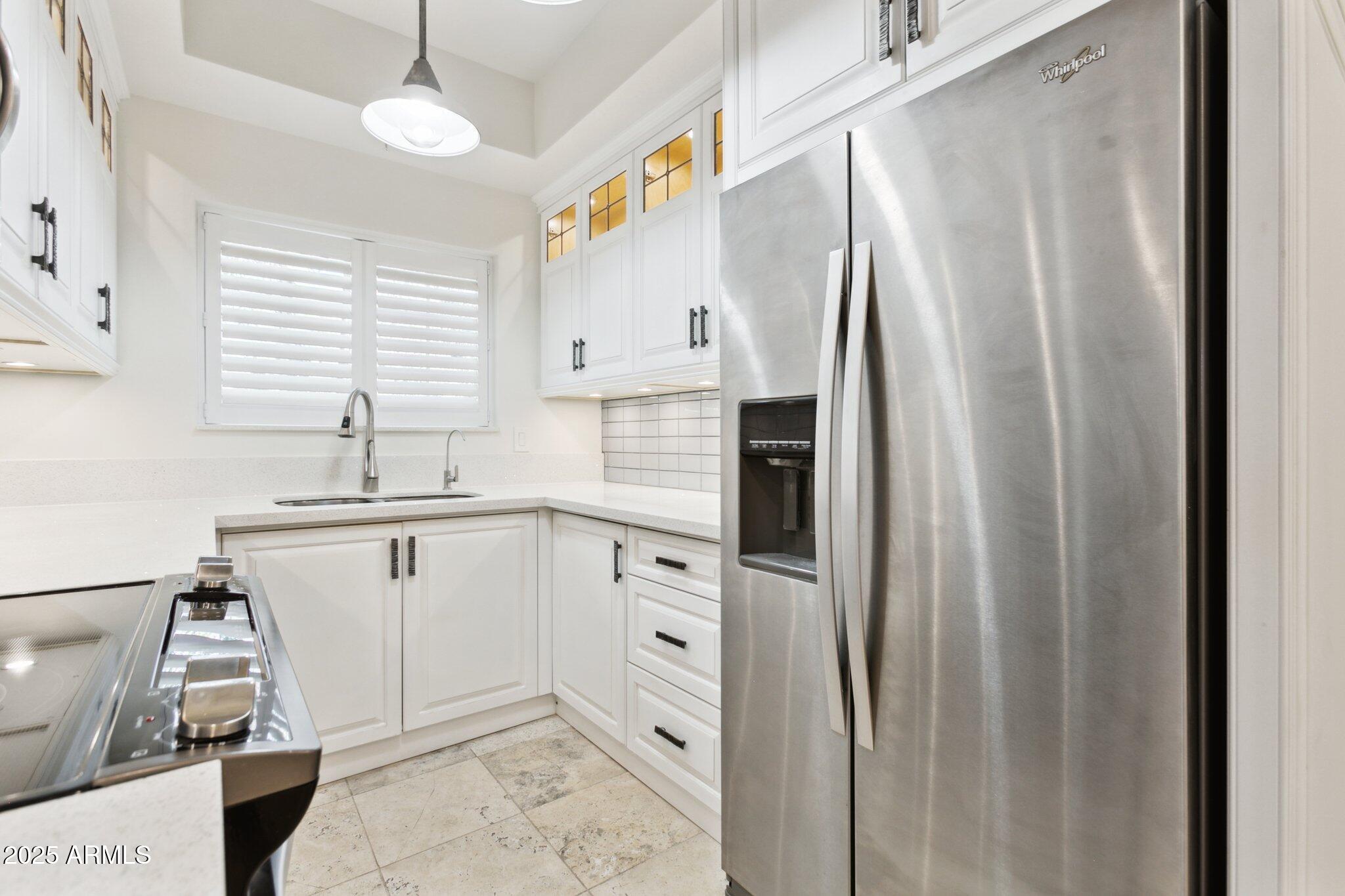 7710 East Gainey Ranch Road, Unit 229 Scottsdale, AZ 85258 - Photo 9 of 50 a kitchen with stainless steel appliances a refrigerator sink and cabinets