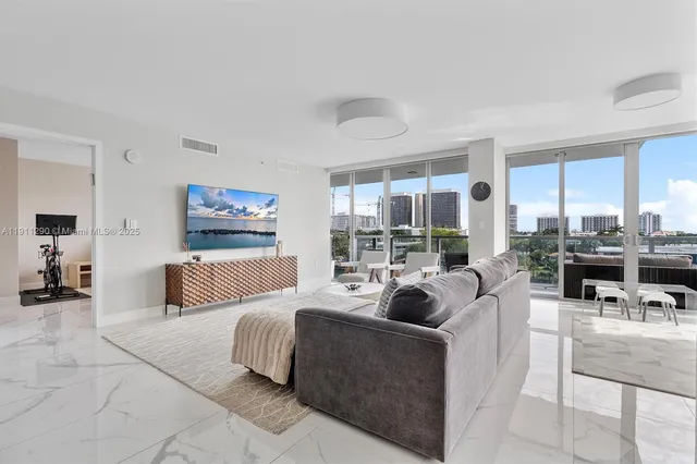 a living room with furniture and a view of kitchen