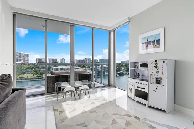 a living room with furniture a large window and stainless steel appliances