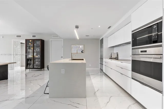 a large white kitchen with a stove a sink and a refrigerator