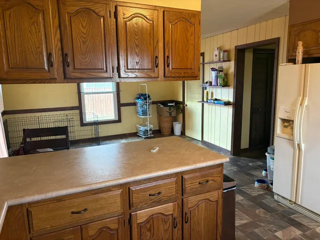 a kitchen with kitchen island a counter top space a sink and cabinets