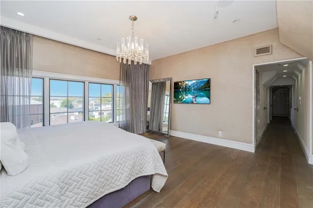 a spacious bedroom with a large bed and a chandelier