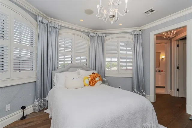 a bedroom with a large bed and a chandelier