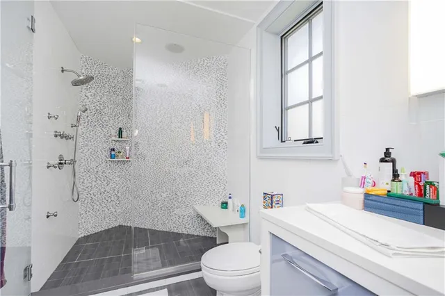 a bathroom with a sink a toilet and shower