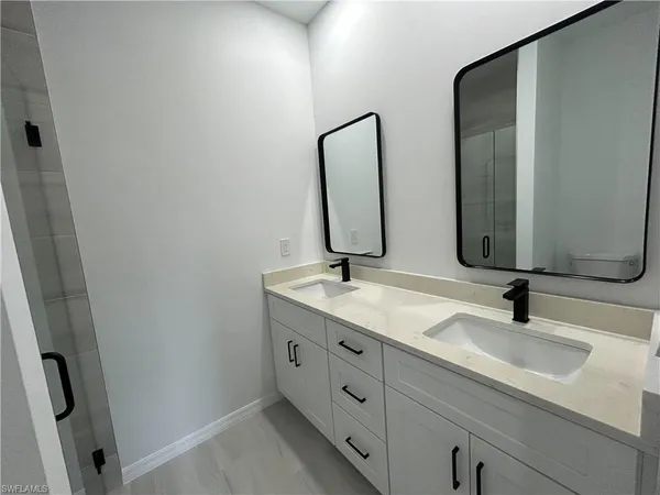 a bathroom with double vanity sink and two mirror