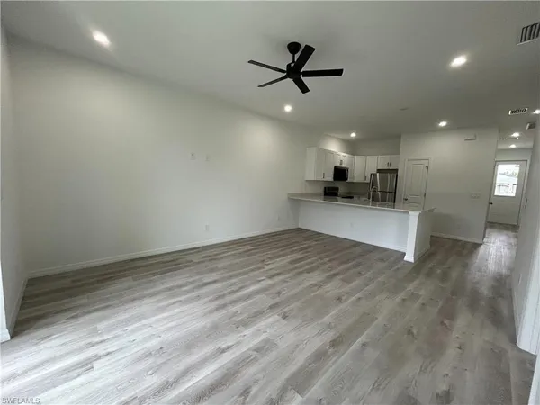 a view of a kitchen with a sink and wooden floor