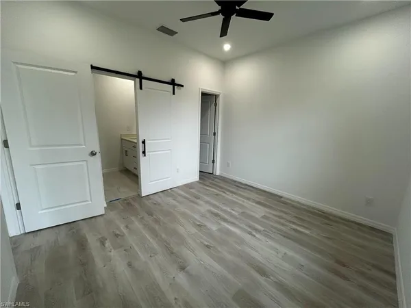 an empty room with a ceiling fan and wooden floor
