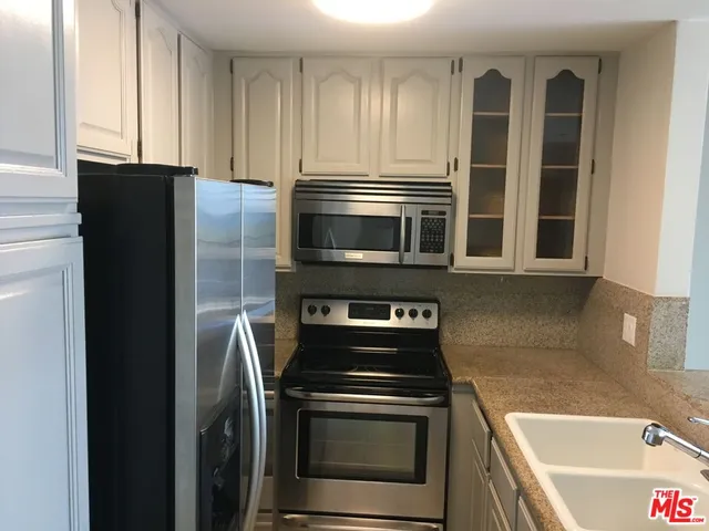 a kitchen with granite countertop a refrigerator and a stove