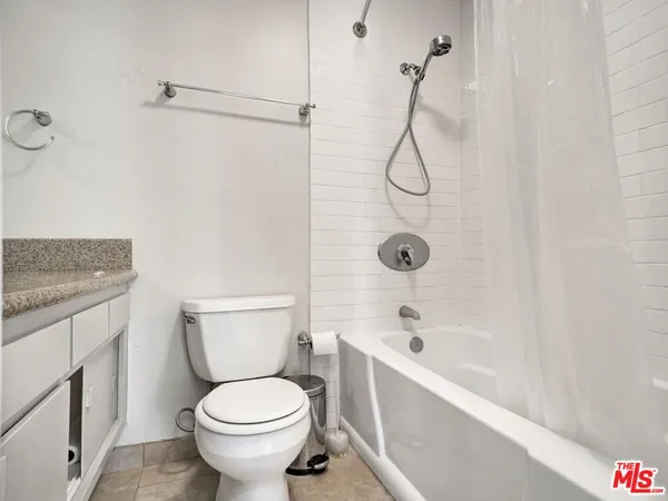 a bathroom with a granite countertop sink a toilet a mirror and vanity