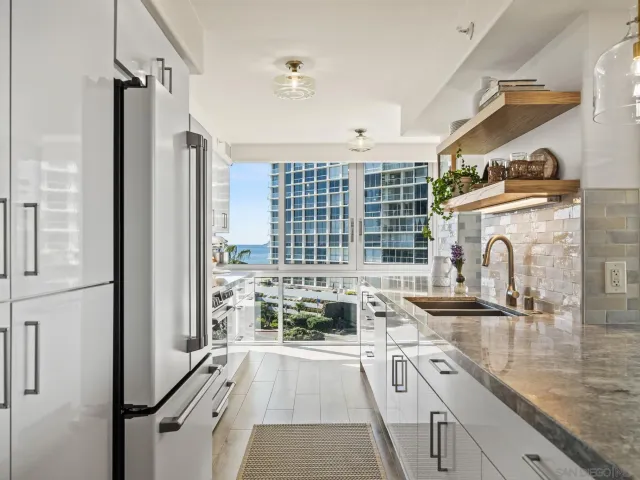 a large white kitchen with lots of counter space wooden floor and appliances