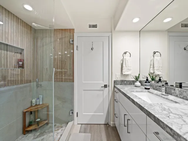 a spacious bedroom with a bed and a flat screen tv