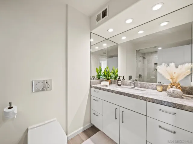a living room with furniture a flat screen tv and a potted plant