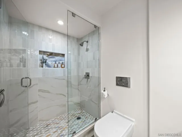 a bathroom with a double vanity sink toilet mirror and shower