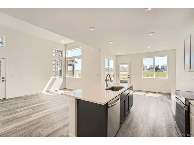 a kitchen with granite countertop a sink and a wooden floor