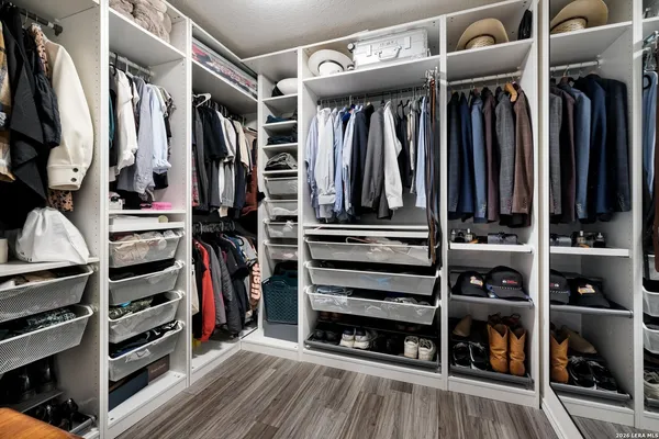 a view of walk in closet with clothes and shoes